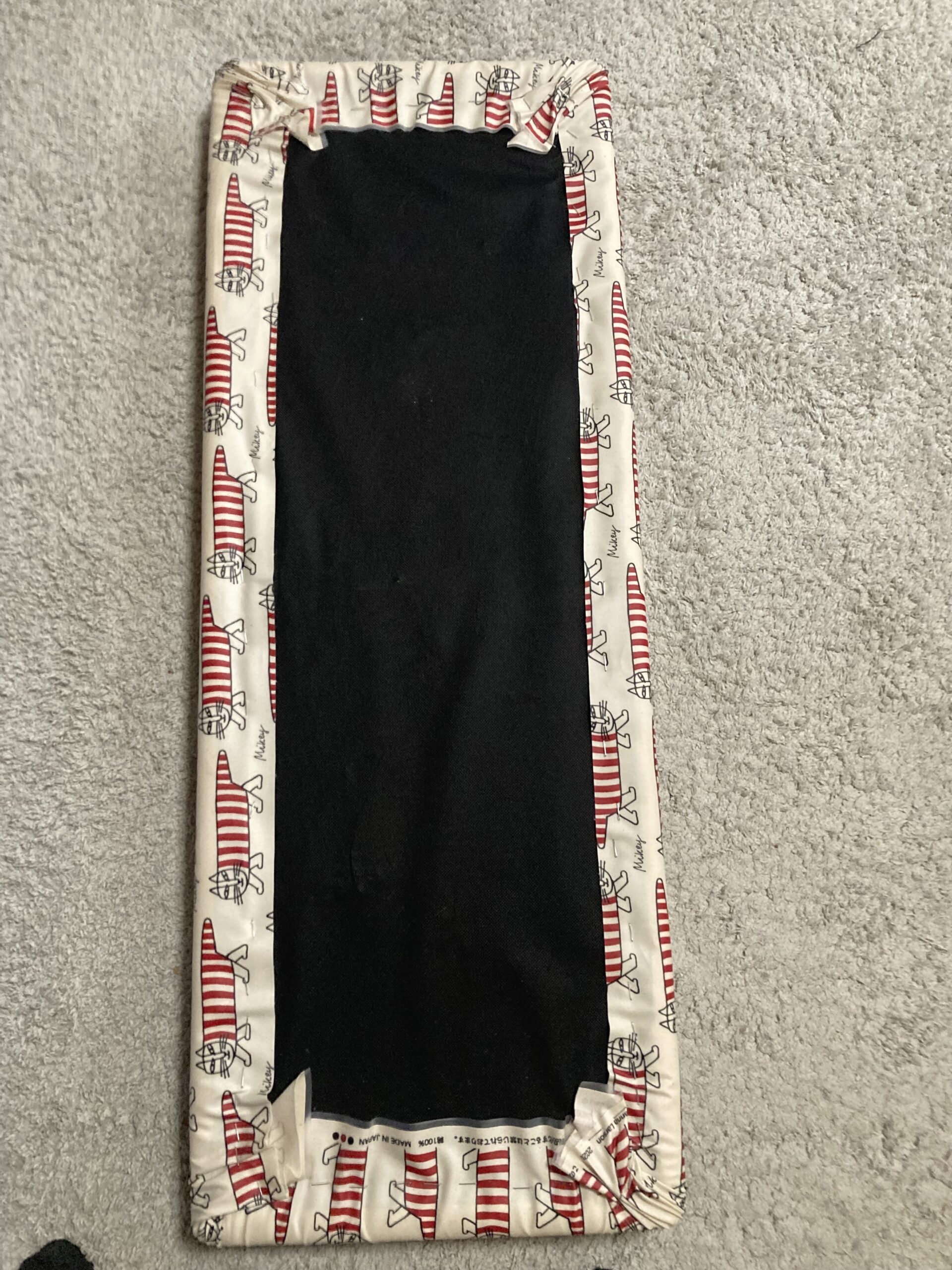 生地をタッカーで座面裏に留める作業